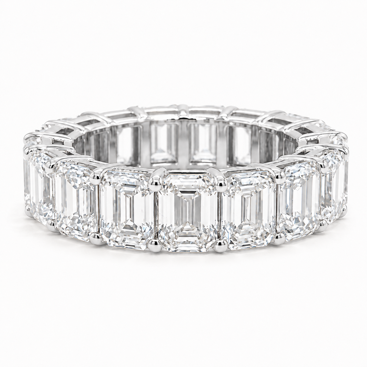 An eternity ring featuring a continuous row of emerald-cut diamonds set in a bright white metal, shown on a clean white background.