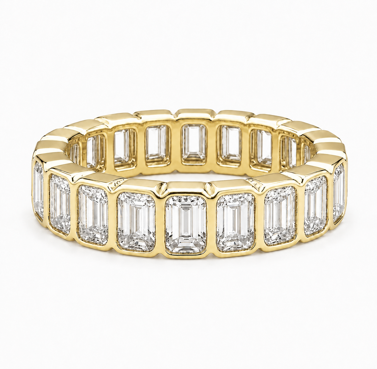 A yellow gold eternity ring featuring a continuous row of baguette-cut clear gemstones in a polished bezel setting, shown on a clean white background.
