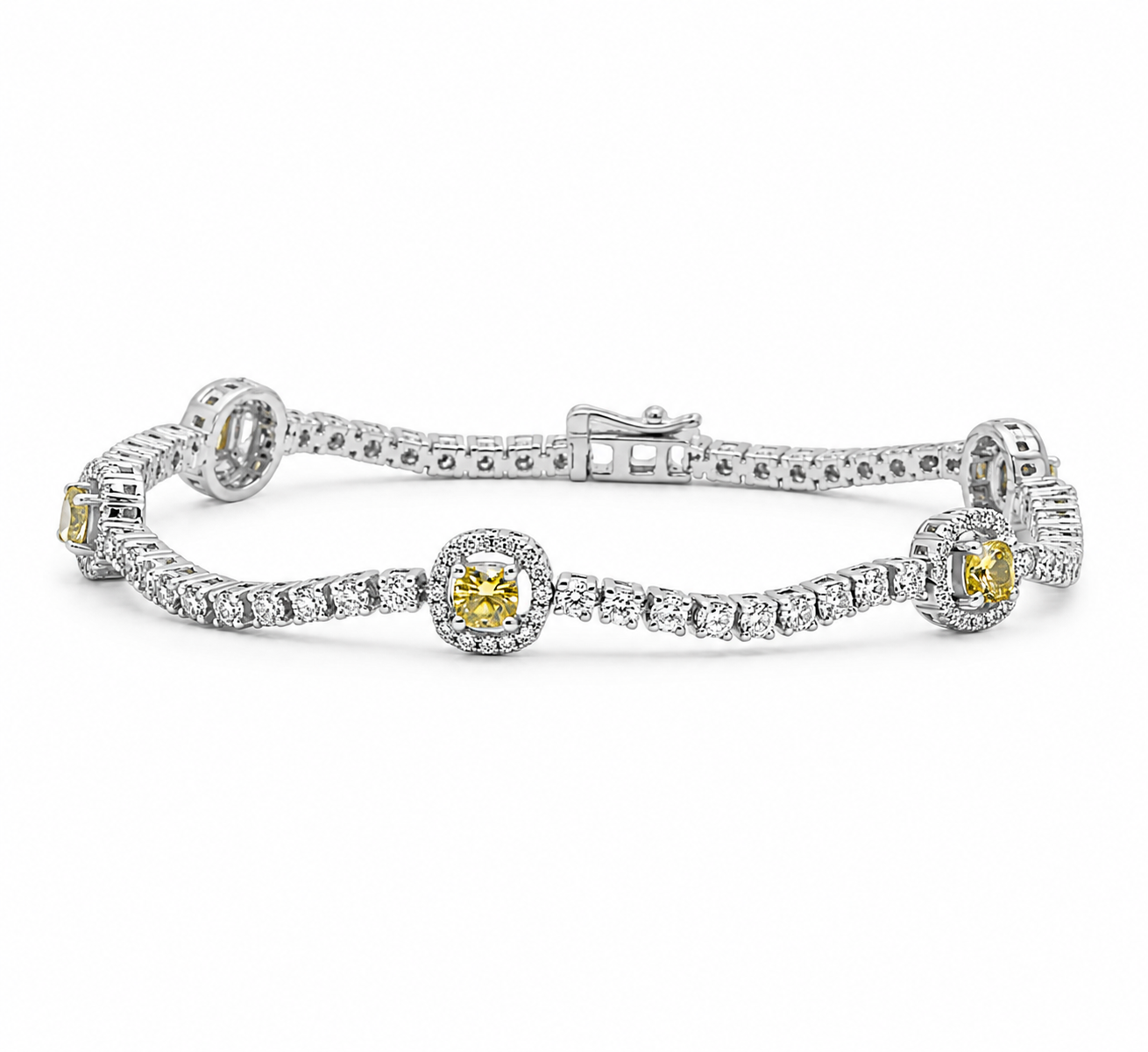 A silver tennis bracelet featuring a row of small clear stones and three larger yellow gemstone centers, each surrounded by a halo, on a plain white background.