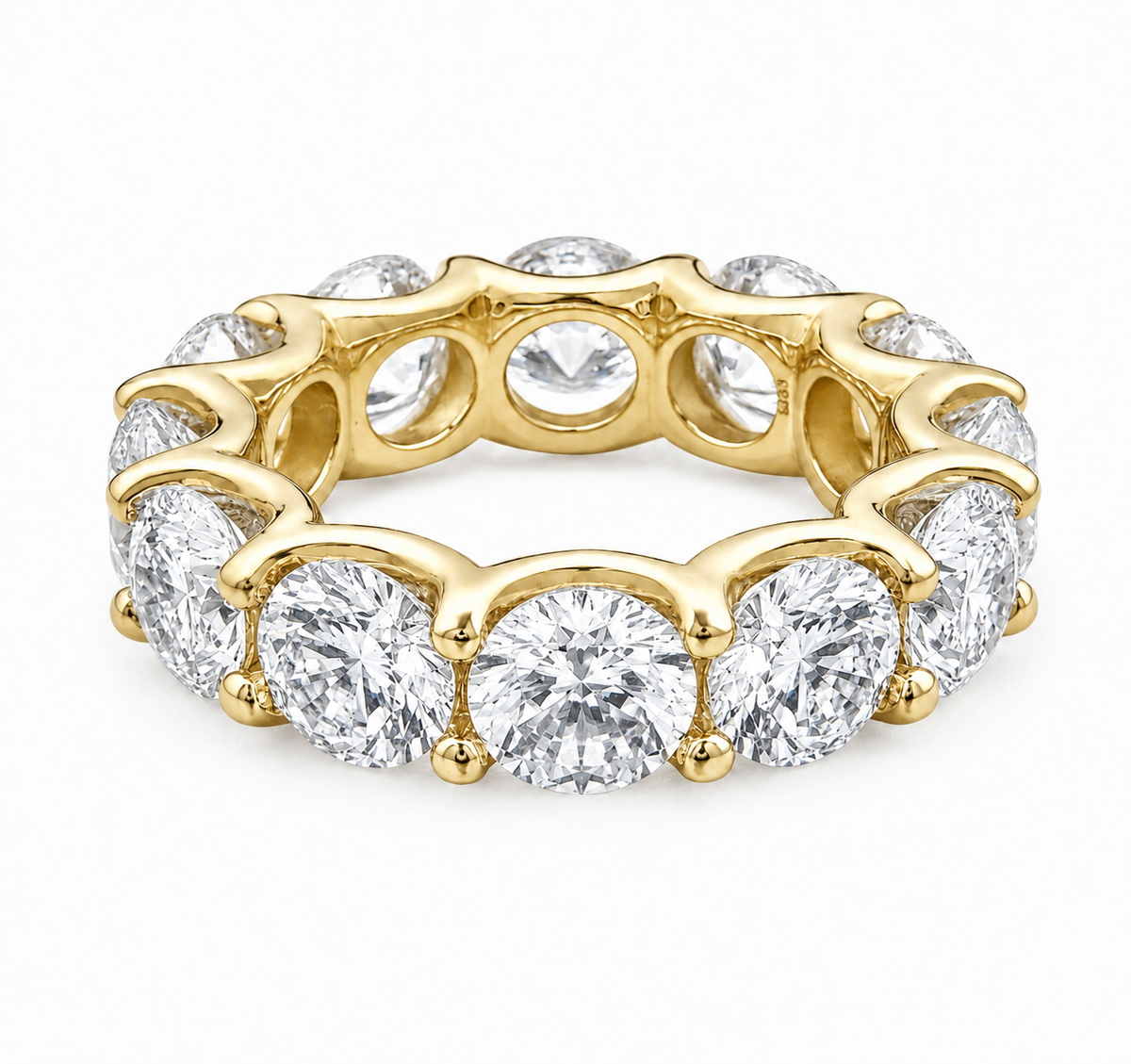 A yellow gold eternity ring featuring a continuous row of round brilliant-cut diamonds in a prong setting, shown on a clean white background.