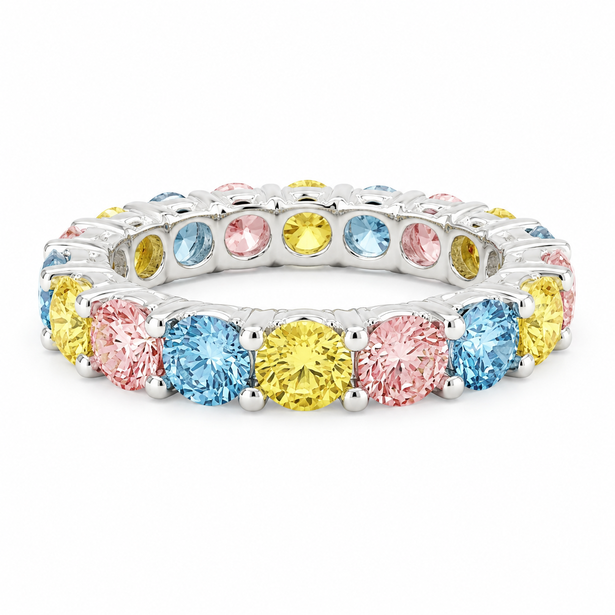 A silver-toned eternity ring featuring alternating round-cut light blue, pink, and yellow gemstones, shown on a clean white background.