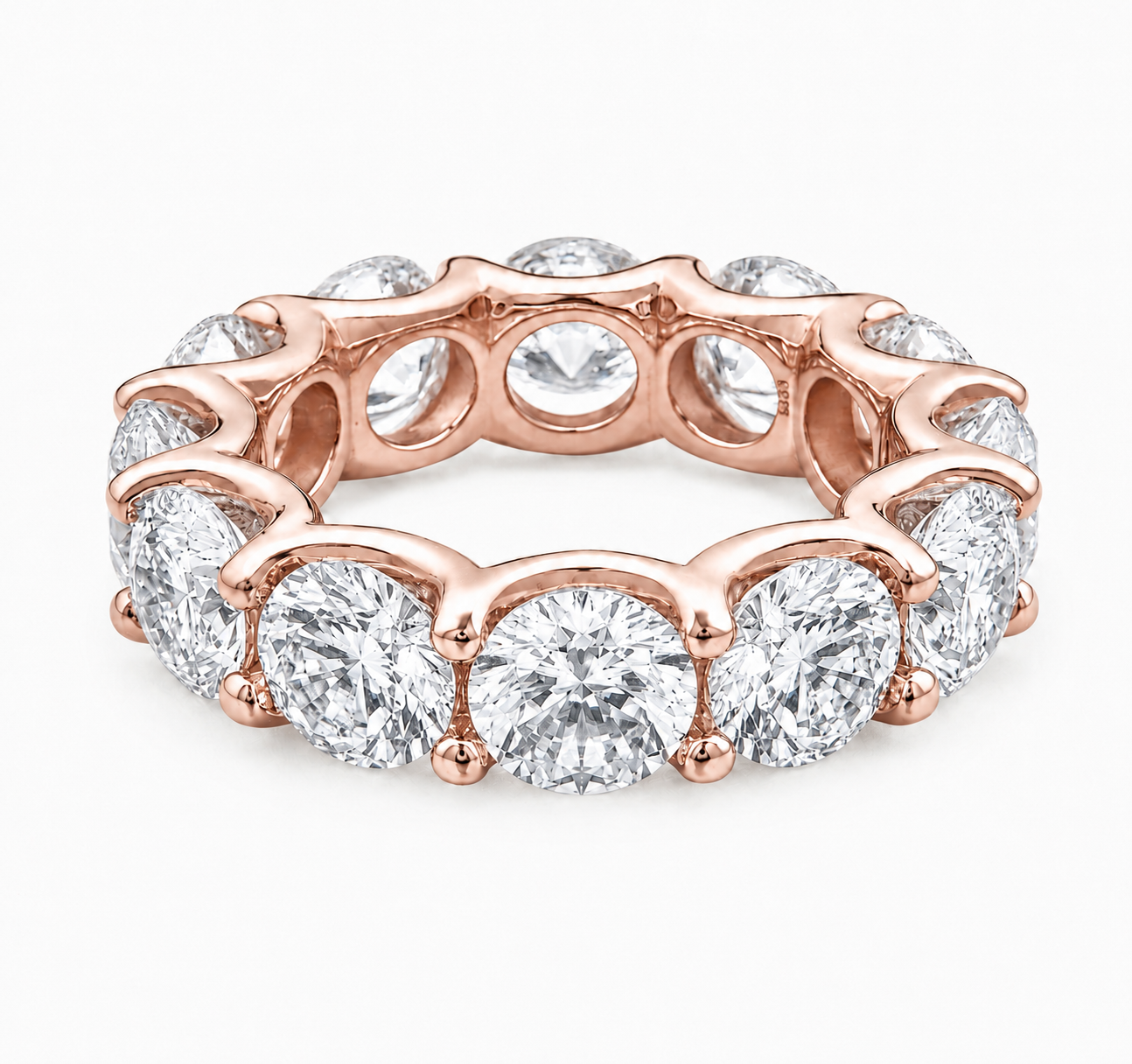 A rose gold eternity band ring featuring a continuous row of round brilliant-cut diamonds in a prong setting, shown on a clean white background.