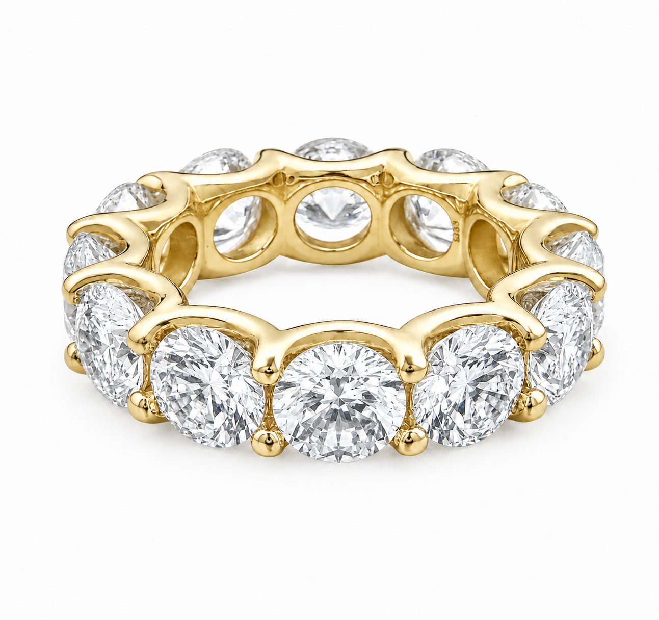 A yellow gold eternity ring featuring a continuous row of round brilliant-cut diamonds in a prong setting, shown on a clean white background.