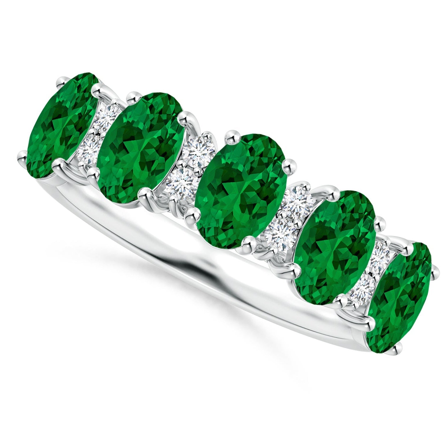 Silver ring with green gemstones on a white background